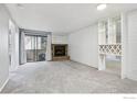Living room with fireplace, wall shelving, and sliding door to patio at 497 S Memphis Way # 10, Aurora, CO 80017