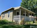 Quaint house with green siding, white trim, and a covered porch at 1009 Pratt St, Longmont, CO 80501