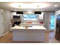 Updated kitchen featuring white cabinets, a large island, and stylish light fixtures at 1022 Kansas Ave, Longmont, CO 80501