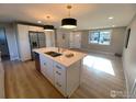 Open concept kitchen and living area with white cabinetry and an island at 1022 Kansas Ave, Longmont, CO 80501