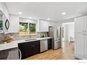 Modern kitchen featuring white cabinets, stainless steel appliances, and stylish backsplash at 1232 Lincoln St, Longmont, CO 80501