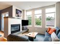 Bright living room with a fireplace, large windows, and comfortable seating at 1505 Pearl St # 209, Boulder, CO 80302