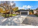 Ranch home with freshly painted exterior, new garage door, and driveway at 35 Dartmouth Cir, Longmont, CO 80503