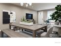 Dining room with a long wooden table, bench, and modern chandelier at 410 High Point Dr # 104, Longmont, CO 80504