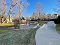 Community pathway alongside a pond with mature trees at 5540 Stonewall Pl # 16, Boulder, CO 80303