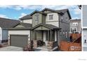 Two-story house with gray and green siding, stone accents, and a two-car garage at 615 W 174Th Pl, Broomfield, CO 80023