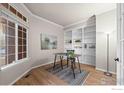 Bright home office featuring custom built-ins, hardwood floors, modern lighting, and large windows at 859 Topaz St, Superior, CO 80027