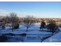 Snowy backyard with a white fence and a view of the city at 11386 Grove St # B, Westminster, CO 80031