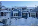 Two-story townhome with a blue exterior and white picket fence at 11386 Grove St # B, Westminster, CO 80031