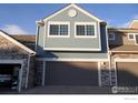 Townhome featuring a two-car garage and stone accents at 11386 Grove St # B, Westminster, CO 80031