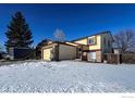 Two-story house with attached garage and a snow-covered yard at 12117 Newport Dr, Brighton, CO 80602