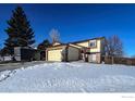 Two-story house with attached garage and a snow-covered yard at 12117 Newport Dr, Brighton, CO 80602