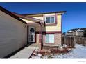 House exterior showcasing a front entrance with brick accents and a decorative gate at 12117 Newport Dr, Brighton, CO 80602