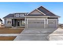 Gray house with stone accents and a three-car garage at 1369 Burt Ave, Berthoud, CO 80513