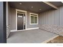 Covered front porch with stone accents and dark brown door at 1369 Burt Ave, Berthoud, CO 80513