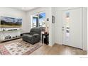 Bright entryway with grey recliner and large windows at 1524 Sun Way, Lafayette, CO 80026