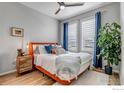 Bedroom with orange bed frame, blue accents, and window with shutters at 2428 Yukon Dr, Longmont, CO 80504