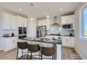 Modern kitchen with white cabinets, stainless steel appliances, and a large island at 2715 Crystal Springs, Longmont, CO 80503