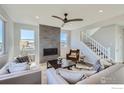 Spacious living room with a stone fireplace, large windows, and comfortable seating at 2715 Crystal Springs, Longmont, CO 80503