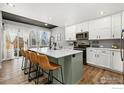 Modern kitchen with a large island, stainless steel appliances, and white cabinets at 306 Se 4Th St, Berthoud, CO 80513