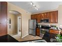 Modern kitchen with stainless steel appliances and dark wood cabinets at 3100 Blue Sky Cir # 308, Erie, CO 80516