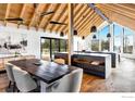 Open concept dining area with large rustic wood table and modern lighting at 3500 Bison Dr, Boulder, CO 80302