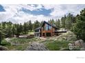 Modern home with a frame of large picture windows, accented by beautiful trees at 3500 Bison Dr, Boulder, CO 80302