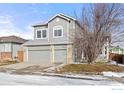 Two-story house with gray siding, three-car garage, and a well-maintained yard at 628 Saint Andrews Dr, Longmont, CO 80504