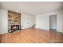 Bright living room with hardwood floors and a stone fireplace at 2021 W 102Nd Ave, Thornton, CO 80260