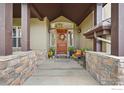 Inviting entryway with a wooden door and stone accents at 2121 Jade Way, Longmont, CO 80504