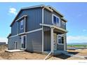 Two-story gray house with white accents, a back deck, and mountain views at 349 Fickel Farm Trl, Berthoud, CO 80513