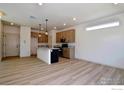 Modern kitchen with light wood cabinets, granite countertops, and an island at 349 Fickel Farm Trl, Berthoud, CO 80513