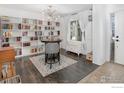 Bright living room with built-in shelving, hardwood floors, and a round table at 4964 Shenandoah Ave, Firestone, CO 80504