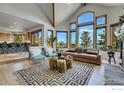 Stylish living area boasts vaulted ceilings, picturesque windows framing mountain views, and an open layout connecting to the kitchen at 57 Whispering Pines Rd, Boulder, CO 80302