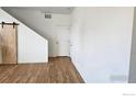 Light and bright hallway with wood flooring and barn door at 6121 Easton Cir, Frederick, CO 80504