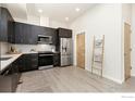 Modern kitchen with dark cabinetry, stainless steel appliances, and white backsplash at 755 Cristo Ln # C, Lafayette, CO 80026