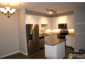 Modern kitchen with granite island, stainless steel appliances, and white cabinets at 804 Summer Hawk Dr # 9106, Longmont, CO 80504