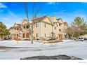 Well-maintained townhome exterior with stone accents and snow-covered landscaping at 9692 W Coco Cir # 201, Littleton, CO 80128