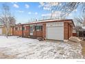 Brick ranch house with attached garage and snowy front yard at 115 17Th Ave, Longmont, CO 80501