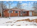 Brick ranch house with attached garage and snowy front yard at 115 17Th Ave, Longmont, CO 80501