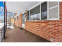 Brick front porch with metal railing and entry door at 115 17Th Ave, Longmont, CO 80501