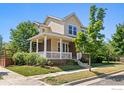 Two-story house with a brick and yellow facade, front porch, and landscaping at 11830 Raleigh Pl, Westminster, CO 80031