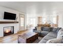 Open concept living room with a fireplace, hardwood floors, and a modern kitchen at 1221 W 144Th Ct, Westminster, CO 80023