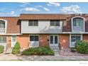 Attractive brick townhouse featuring a double-door entry and landscaping at 12974 W Virginia Ave, Lakewood, CO 80228