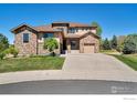 Two-story house with stone accents and a three-car garage at 13699 Pecos Loop, Broomfield, CO 80023