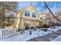 Two-story yellow house with snowy front yard and white picket fence at 1494 Yaupon Ave, Boulder, CO 80304