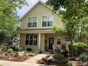 Two-story yellow home with landscaped front yard and rocking chairs on porch at 1494 Yaupon Ave, Boulder, CO 80304