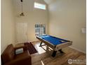 Game room with pool table, hardwood floors, and high ceilings at 1937 Reliance Cir, Superior, CO 80027