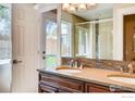 Bright bathroom with double vanity, quartz counters, and a glass-enclosed shower at 2471 Harlan St, Edgewater, CO 80214