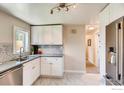 Modern kitchen featuring white cabinetry, stainless steel appliances, and a tiled backsplash at 2471 Harlan St, Edgewater, CO 80214